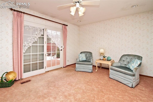 sitting room with ceiling fan and carpet flooring