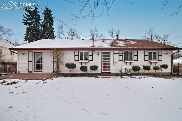 view of snow covered back of property