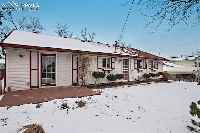 view of snow covered back of property