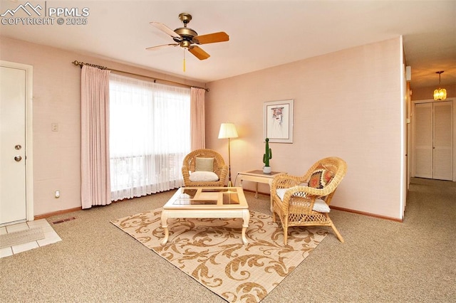 living area featuring ceiling fan and carpet