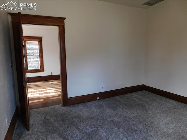 unfurnished room featuring dark carpet