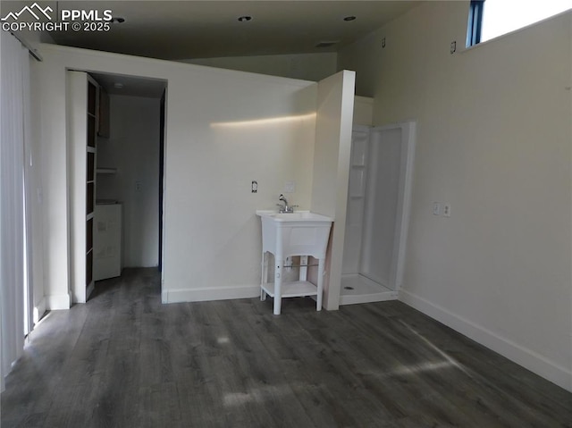 unfurnished room featuring vaulted ceiling and dark hardwood / wood-style flooring