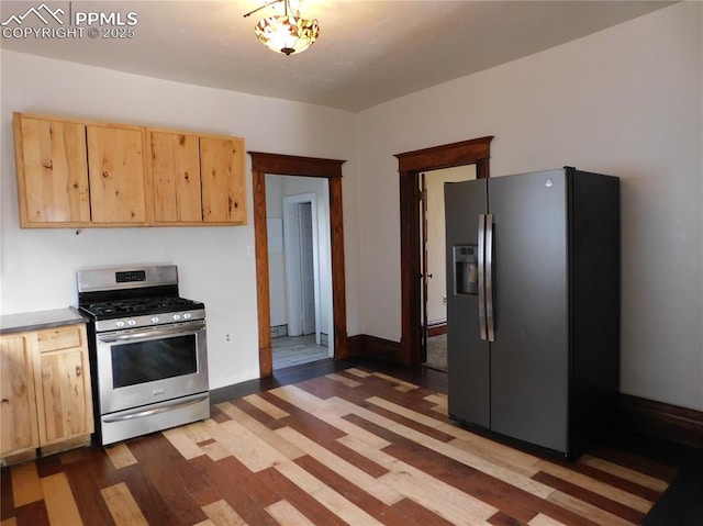 kitchen with light hardwood / wood-style floors, light brown cabinetry, a baseboard heating unit, and stainless steel appliances