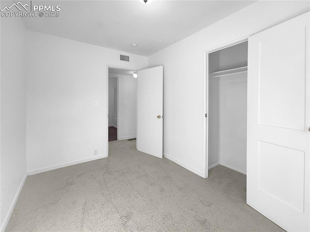 unfurnished bedroom featuring a closet and light carpet