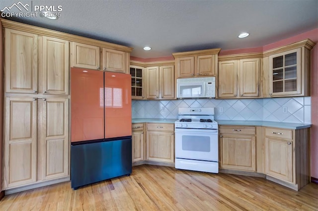 kitchen with light brown cabinets, backsplash, white appliances, and light hardwood / wood-style floors