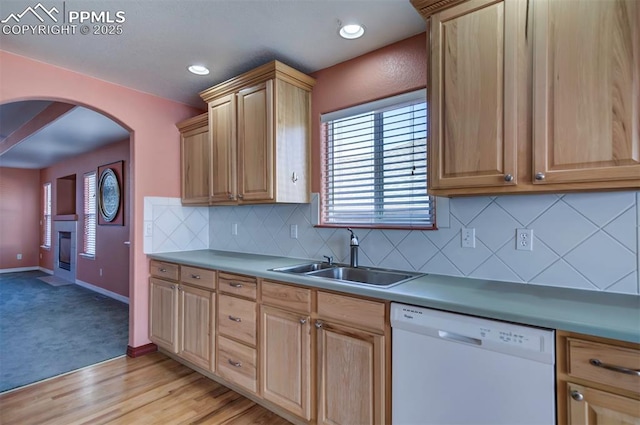 kitchen with light brown cabinetry, sink, tasteful backsplash, light wood-type flooring, and dishwasher