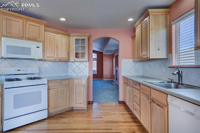 kitchen featuring white appliances, light brown cabinetry, and sink