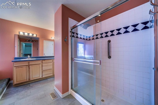 bathroom with tile patterned flooring, vanity, and an enclosed shower