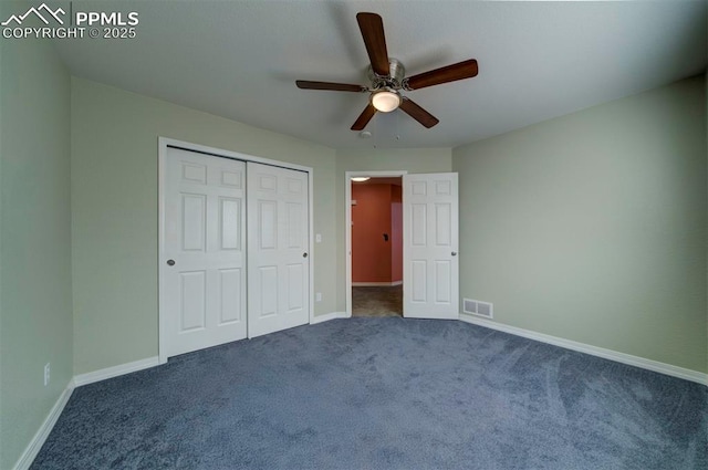 unfurnished bedroom with dark carpet, ceiling fan, and a closet