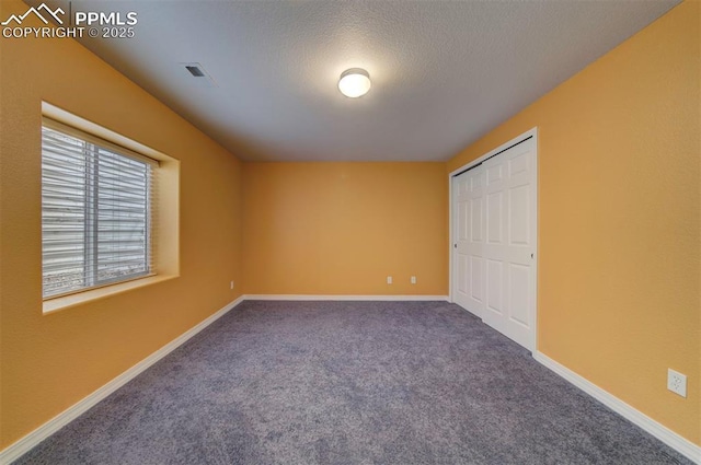 unfurnished bedroom with a closet, a textured ceiling, and carpet flooring