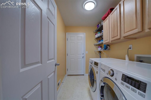 laundry room with separate washer and dryer, cabinets, and a textured ceiling