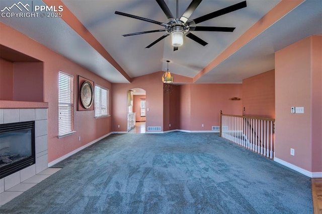 unfurnished living room with ceiling fan, carpet floors, a fireplace, and vaulted ceiling