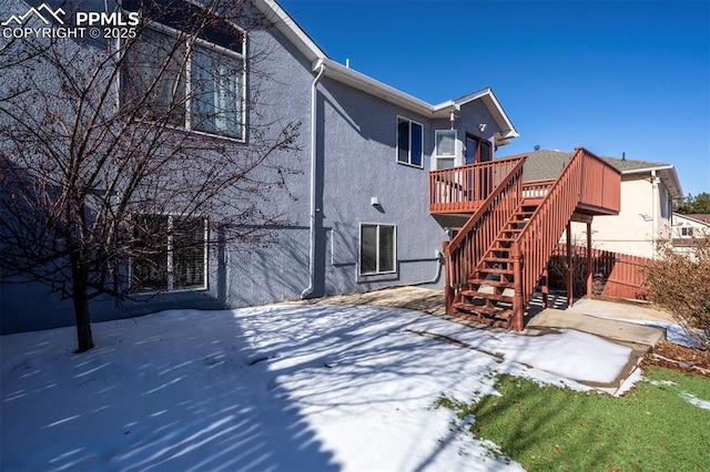 rear view of property with a wooden deck and a patio area