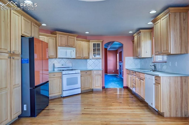 kitchen featuring white appliances, light brown cabinetry, sink, and light wood-type flooring