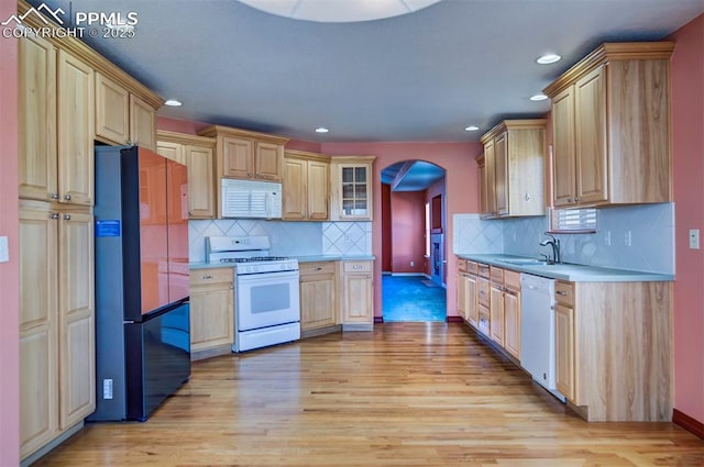 kitchen featuring sink, light brown cabinets, white appliances, and light hardwood / wood-style flooring