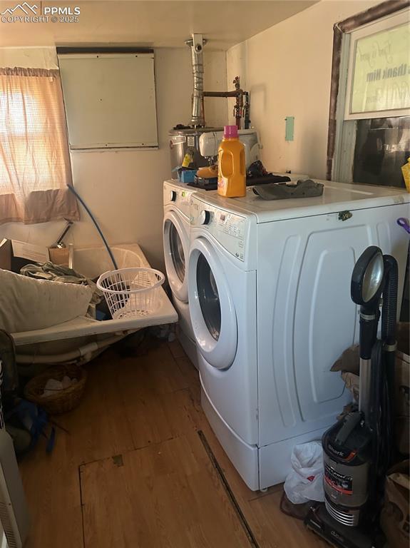 laundry room with washing machine and dryer and light hardwood / wood-style floors