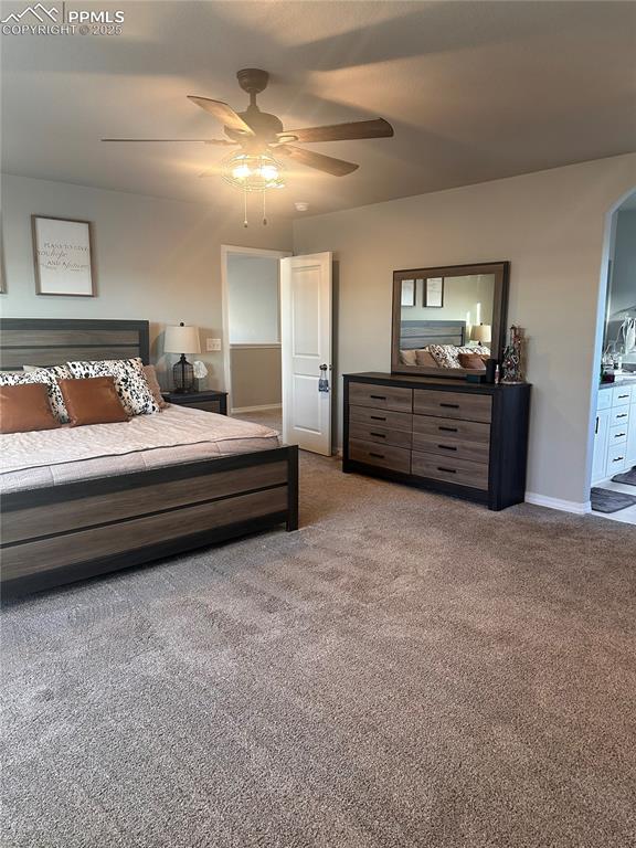 bedroom with ceiling fan, light carpet, and connected bathroom