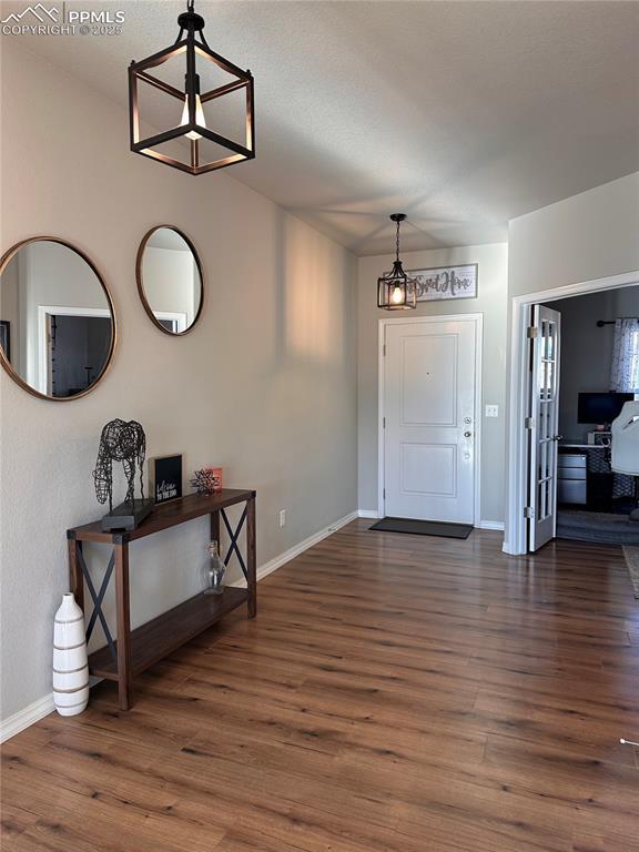 entrance foyer featuring dark wood-type flooring and a chandelier