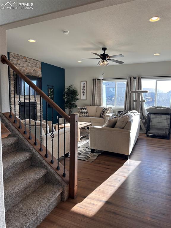 living room featuring ceiling fan and dark hardwood / wood-style floors