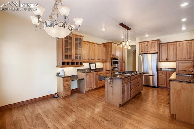 kitchen featuring sink, hanging light fixtures, a center island, light hardwood / wood-style floors, and stainless steel appliances