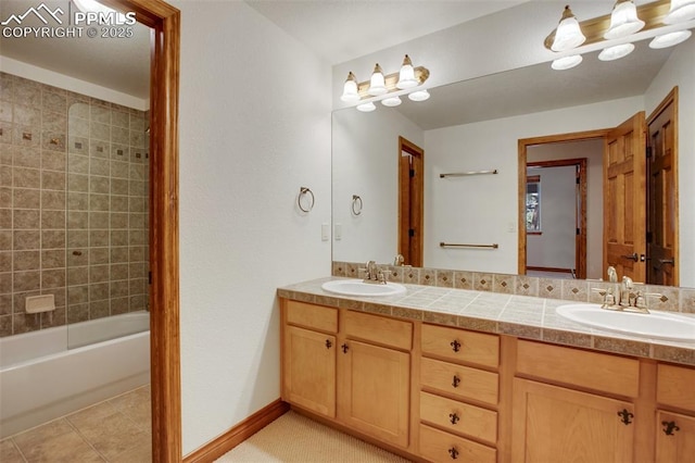 bathroom with tile patterned flooring, vanity, and tiled shower / bath