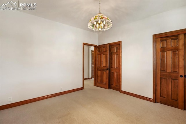 unfurnished bedroom featuring light carpet and an inviting chandelier