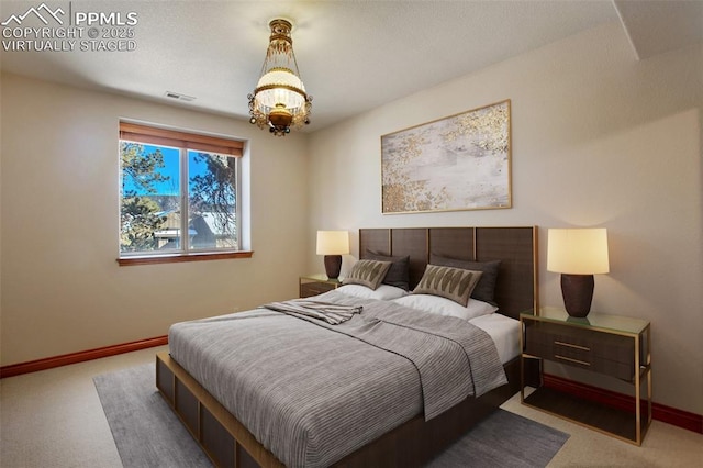 bedroom featuring a notable chandelier and carpet floors