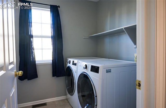 laundry room featuring washer and clothes dryer and light tile patterned flooring