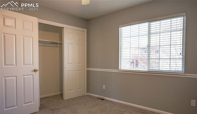 unfurnished bedroom with carpet floors, ceiling fan, and a closet