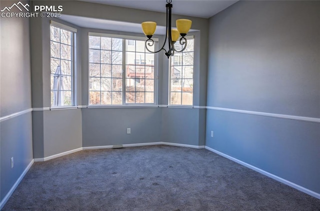 carpeted spare room with a notable chandelier