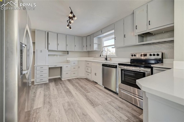 kitchen with sink, stainless steel appliances, and light wood-type flooring