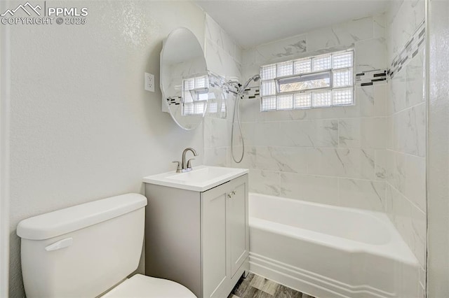 full bathroom with hardwood / wood-style flooring, tiled shower / bath, vanity, and toilet