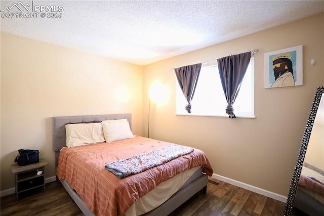 bedroom with a textured ceiling and dark hardwood / wood-style floors