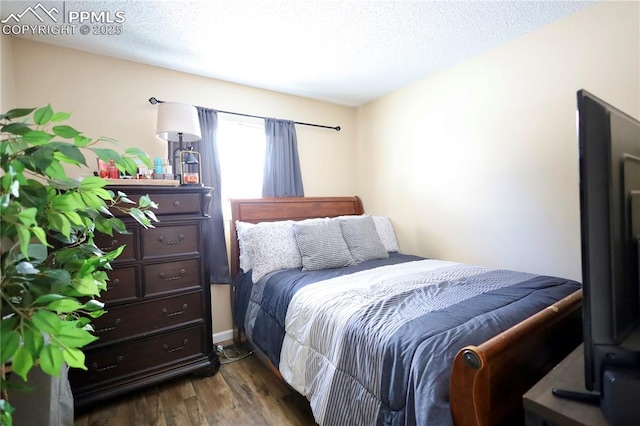 bedroom featuring a textured ceiling and dark wood-type flooring