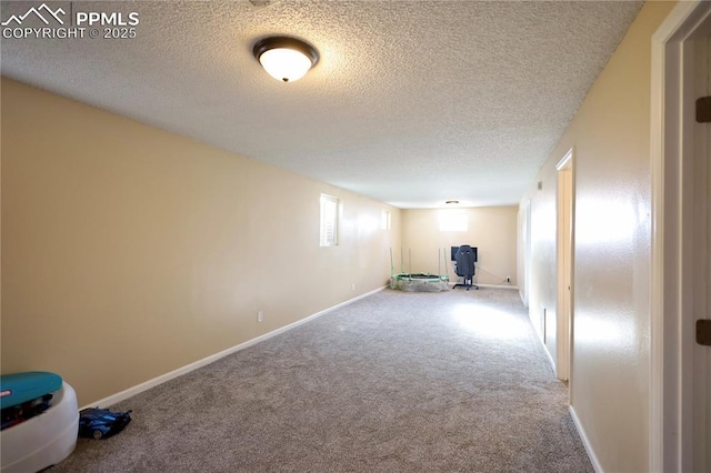 basement featuring a textured ceiling and carpet floors