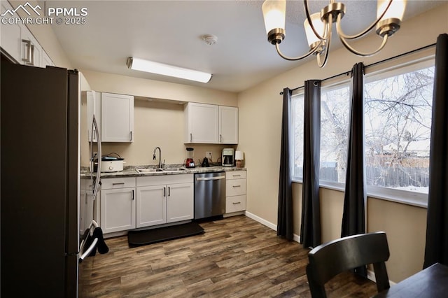 kitchen featuring an inviting chandelier, appliances with stainless steel finishes, white cabinetry, and sink