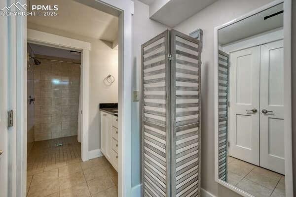 bathroom with vanity, tile patterned flooring, and tiled shower