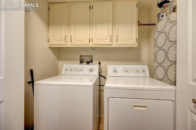 clothes washing area featuring cabinets and separate washer and dryer