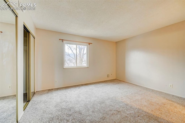 unfurnished bedroom featuring carpet flooring and a textured ceiling