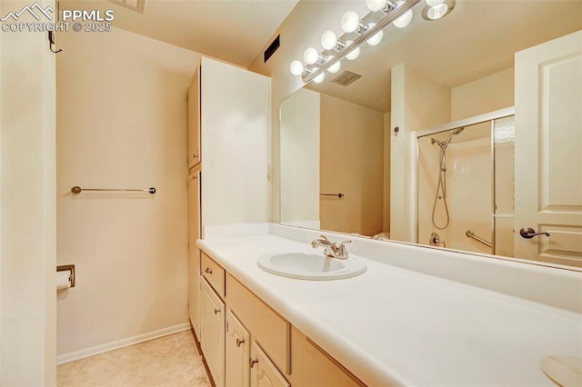 bathroom featuring a shower with door and vanity