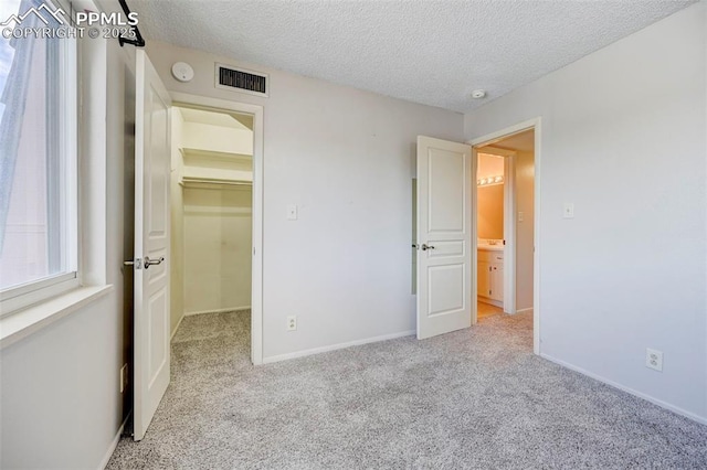 unfurnished bedroom featuring light colored carpet and a textured ceiling