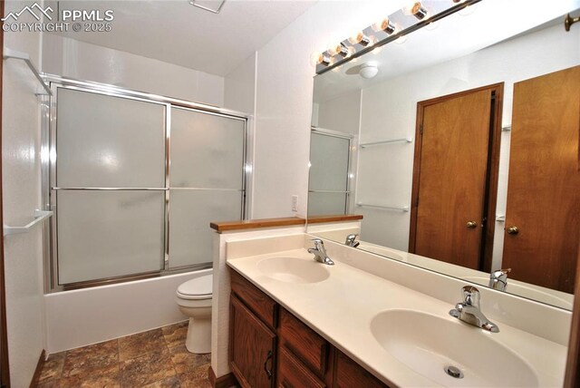 full bathroom with shower / bath combination with glass door, vanity, and toilet