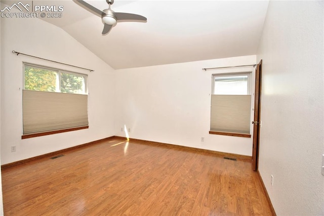 unfurnished room with ceiling fan, vaulted ceiling, plenty of natural light, and hardwood / wood-style floors