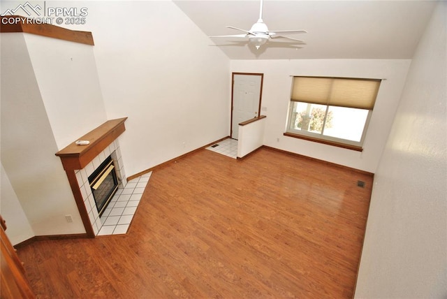 unfurnished living room featuring ceiling fan, light wood-type flooring, and a fireplace