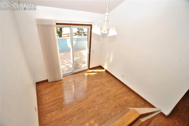 unfurnished dining area with hardwood / wood-style flooring and an inviting chandelier