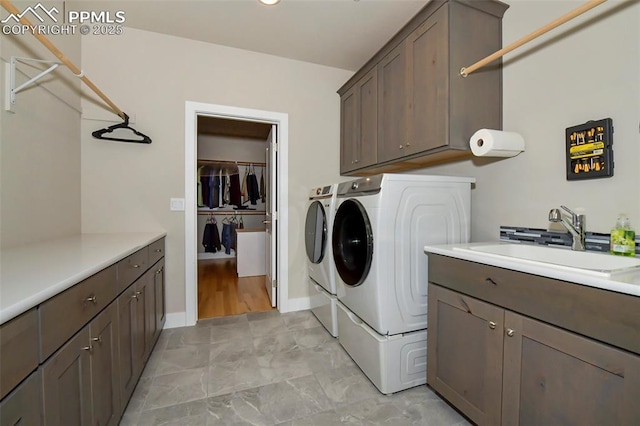 clothes washing area featuring cabinets, separate washer and dryer, and sink