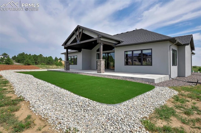 back of property featuring a patio area and a yard