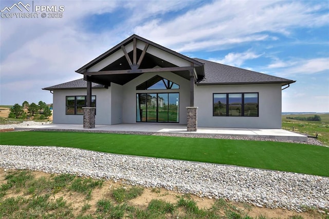 rear view of property featuring a lawn and a patio area