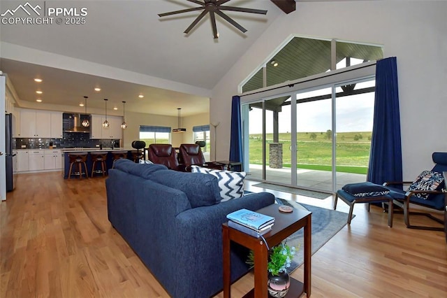 living room featuring beam ceiling, high vaulted ceiling, and light hardwood / wood-style flooring