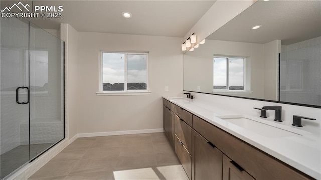 full bathroom with a stall shower, a sink, baseboards, and recessed lighting